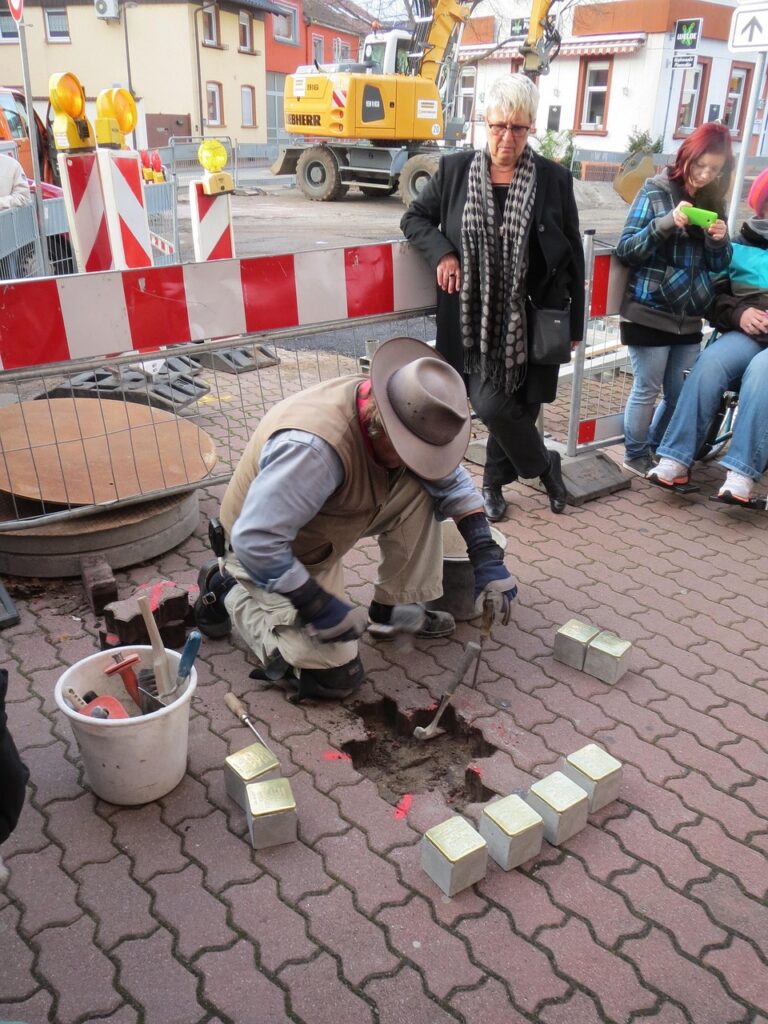 Foto van Gunter Demnig die een stolperstein plaatst