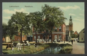 Ansicht van het raadhuis in Lekkerkerk rond 1910. Met weiland en koeien op de voorgrond